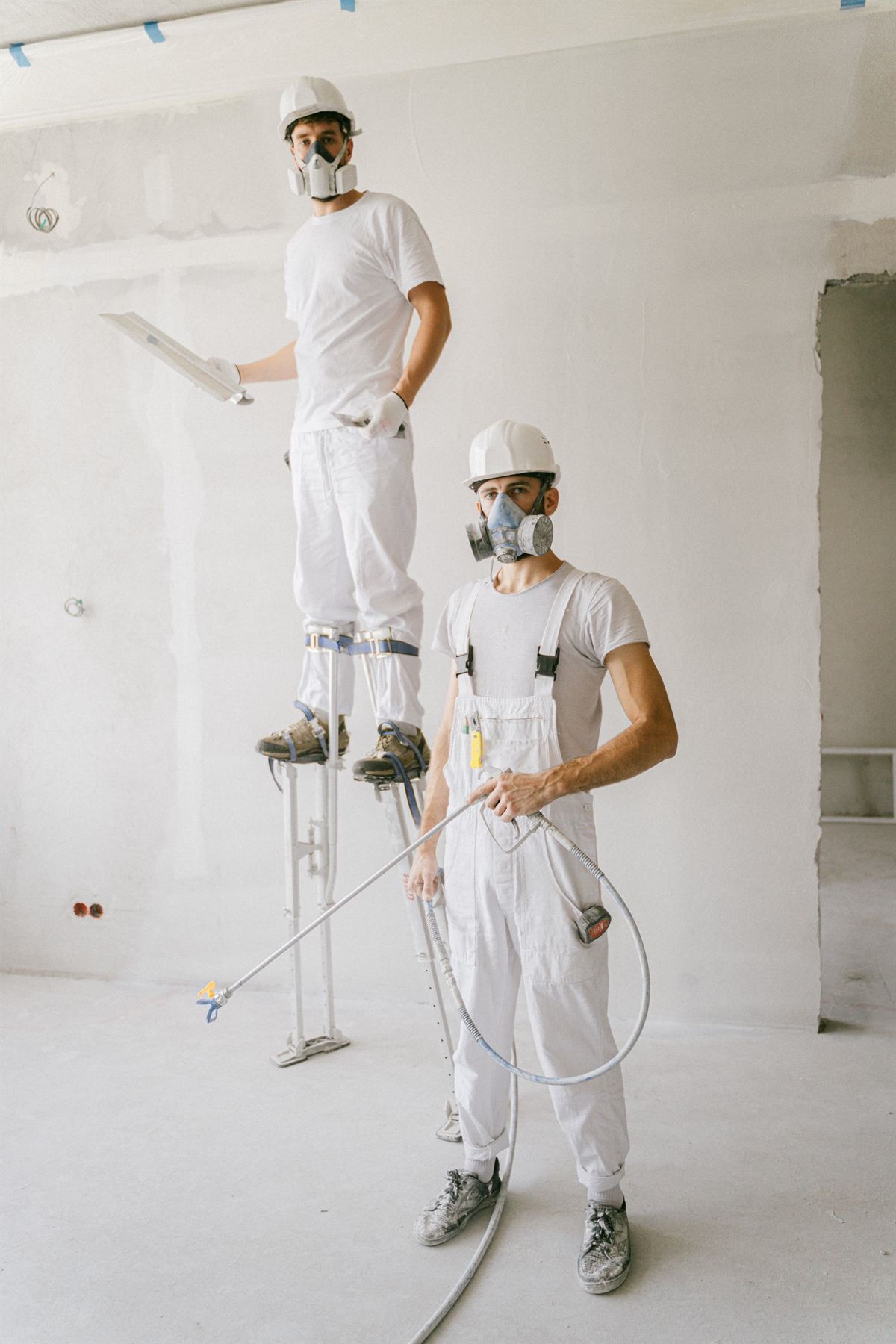 Two painters in whites on a job site